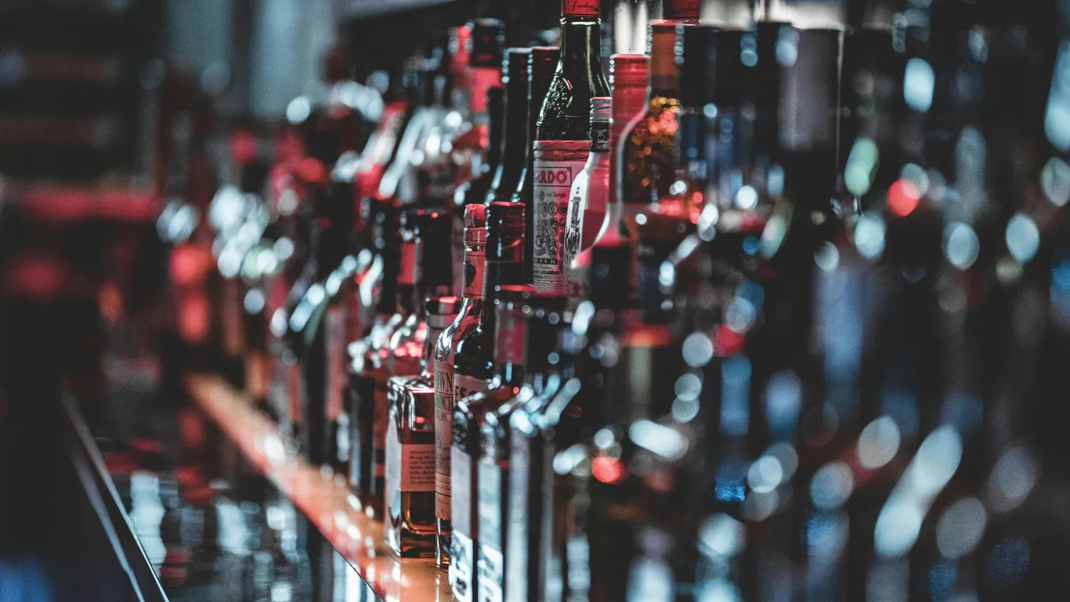 A decorative image of a bar with several bottles on it