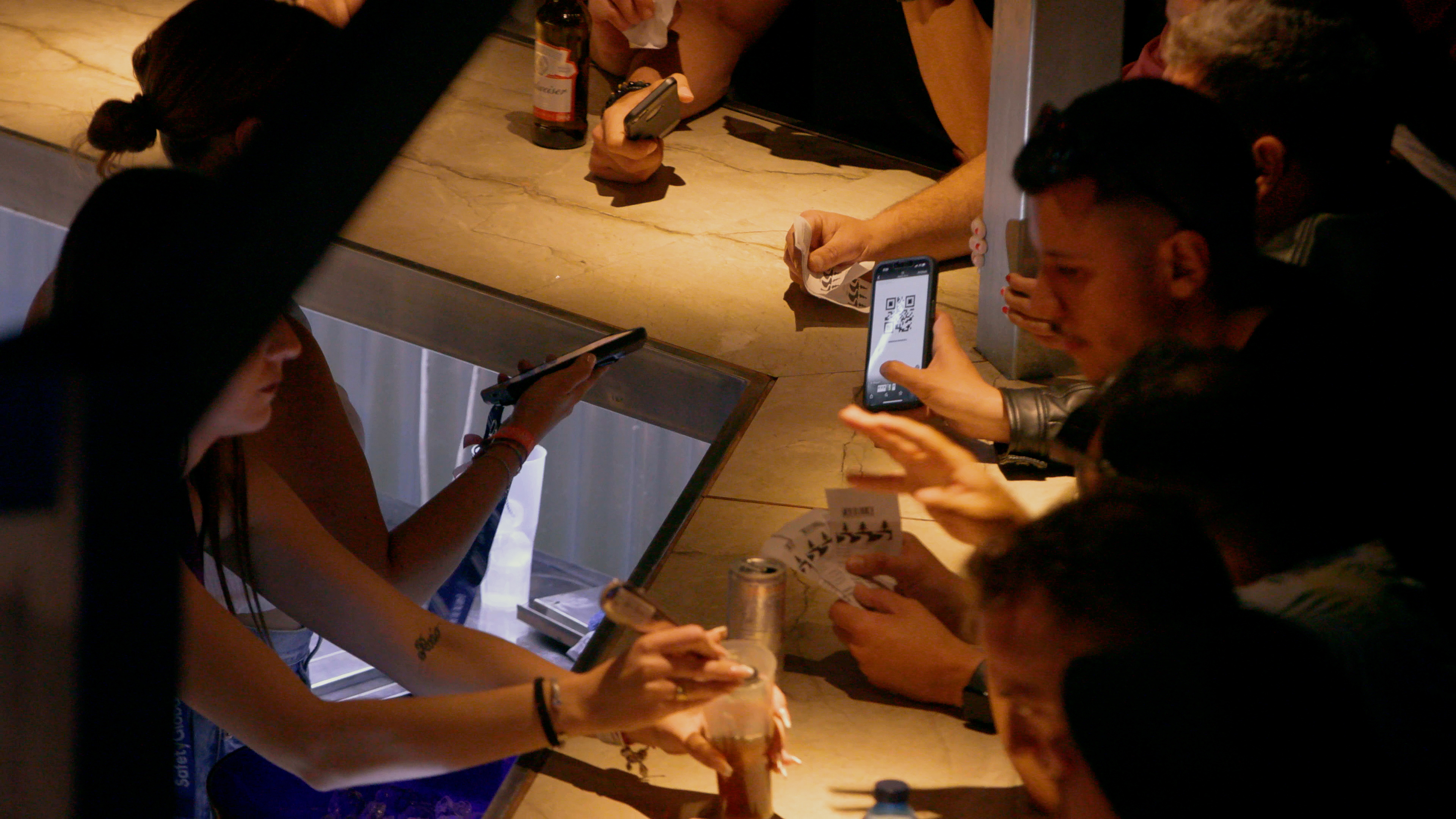 A bartender scanning a QR to a client