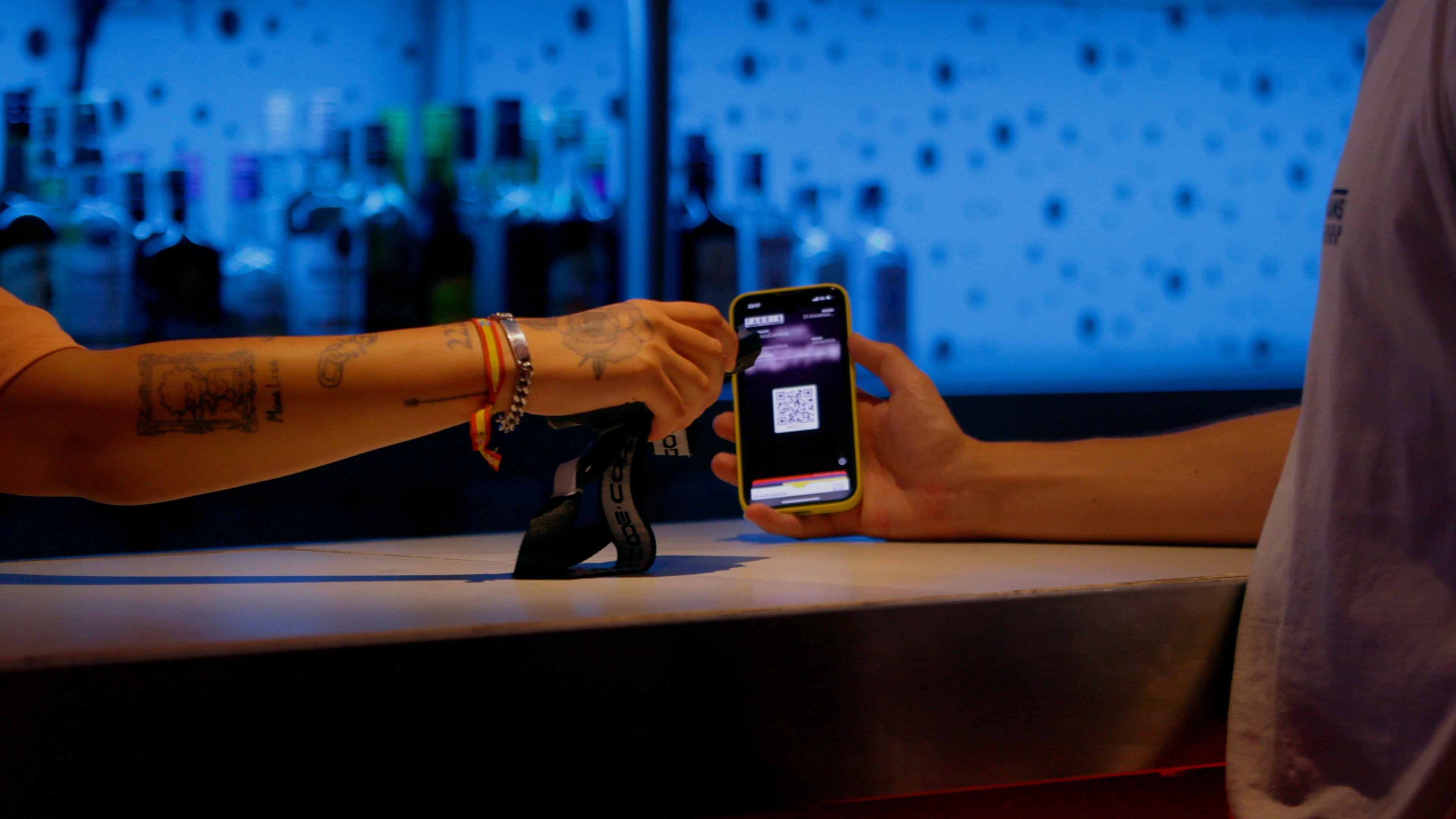 Photo of attendee showing a QR code to be validated by a bartender.