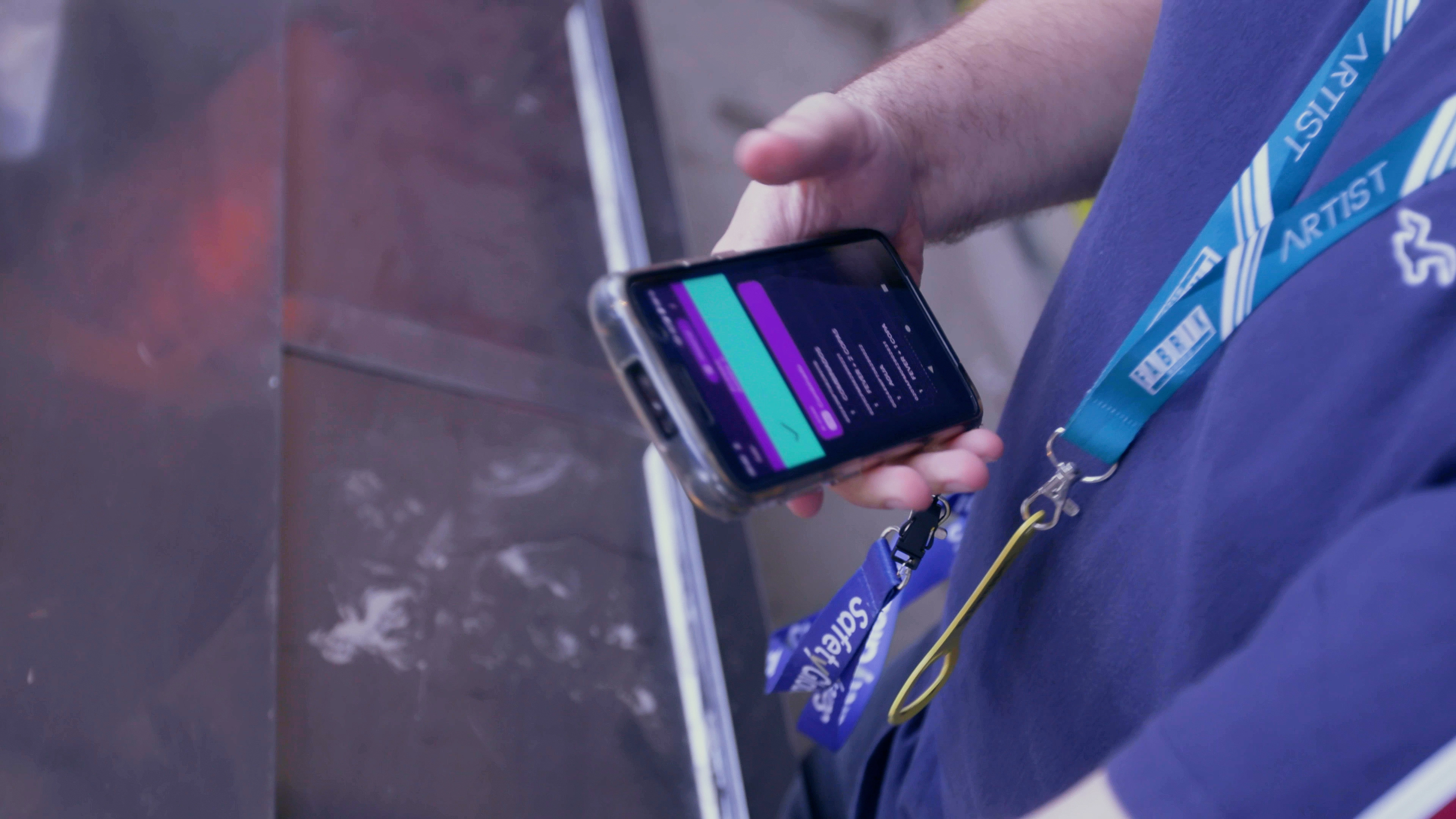 Photo of a bartender holding a scanner that shows the the Festea Scanner app.